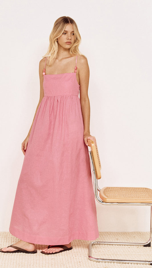 Model wearing Rose Linen Blend Maxi Dress with Bead Detail in pink, featuring adjustable straps and gathered skirt.