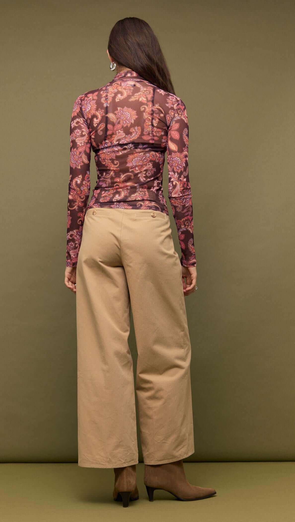 Back view of model wearing Sheer Printed Long Sleeve Mesh Top paired with beige wide-leg pants.