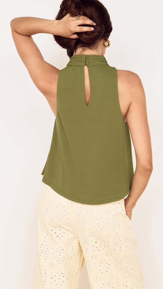 Back view of the Green High Neck Jersey Top with a keyhole detail, styled with light-colored pants.