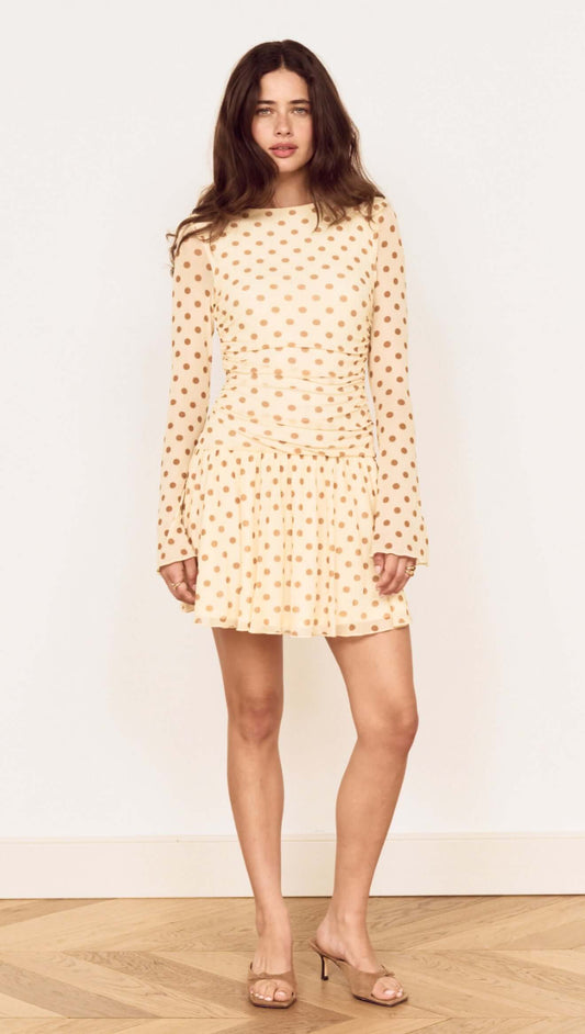 Butter Yellow Polka Dot Mini Dress with Drop Waist worn by a model, showcasing playful polka dots and a flared skirt.