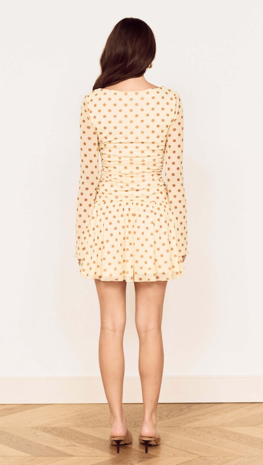 Back view of a Butter Yellow Polka Dot Mini Dress with Drop Waist featuring long sleeves and flared skirt.