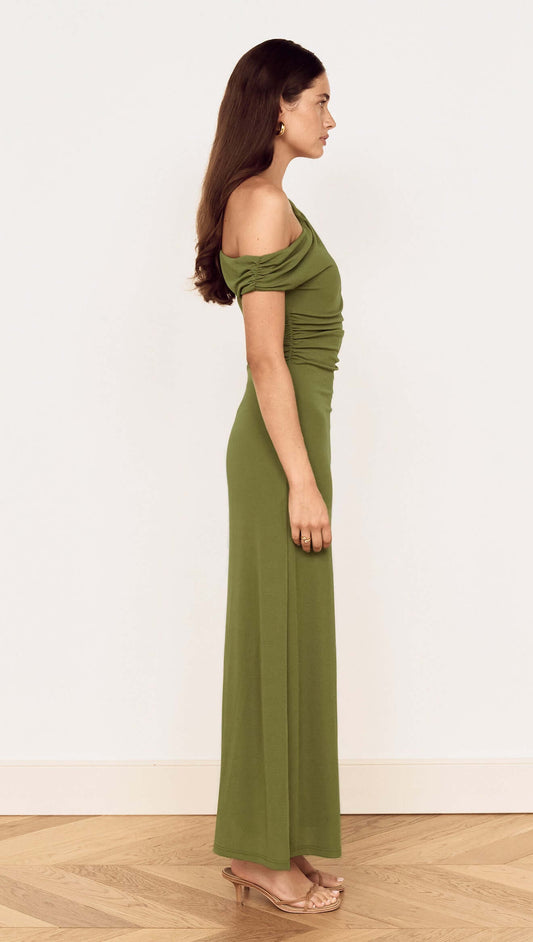 Side view of a woman wearing a Green One Shoulder Mesh Midi Dress, showcasing its fitted silhouette and off-shoulder design.