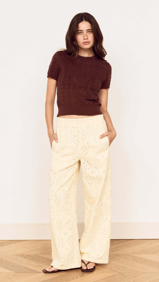 Model wearing a Brown Scallop Edge Knitted Tee with cream wide-leg pants, showcasing a chic and casual outfit.