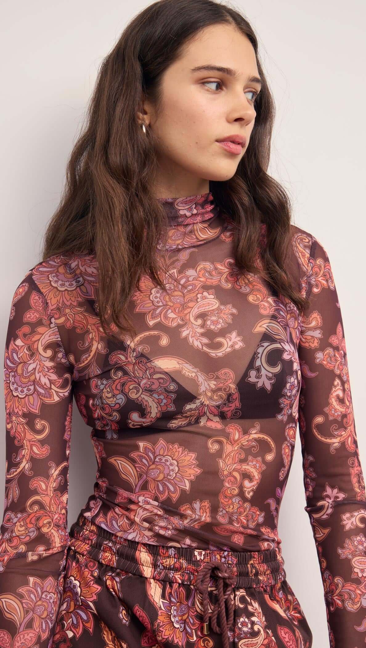 Sheer Printed Long Sleeve Mesh Top in floral print featuring a fitted silhouette and high neckline.
