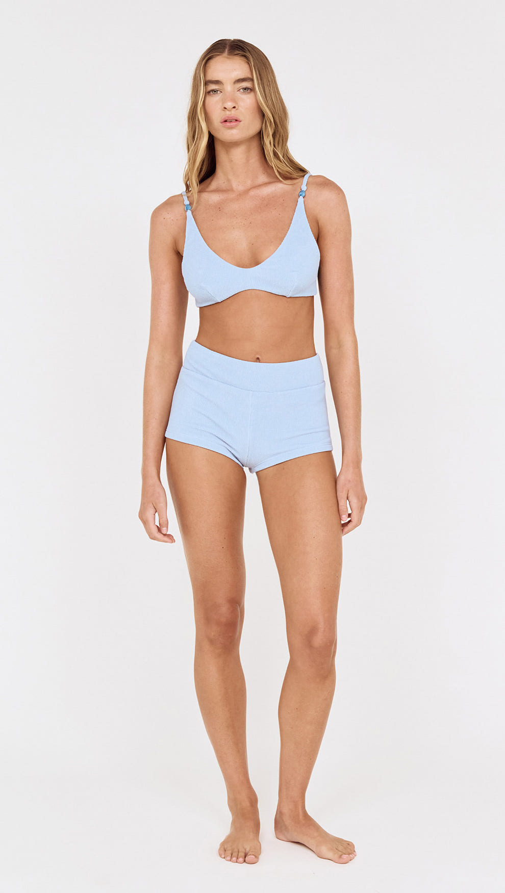 Model wearing textured swim shorts in sky blue and matching bikini top, ideal for beach days and poolside events.