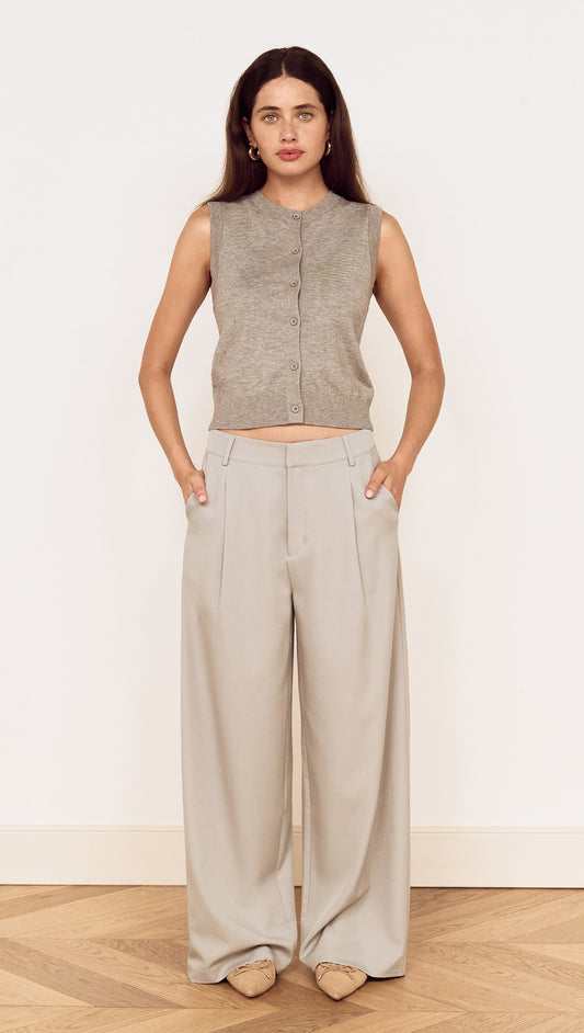 Model wearing Mid Rise Tailored Suit Pant in Grey with a grey sleeveless top, showcasing a relaxed and polished look.