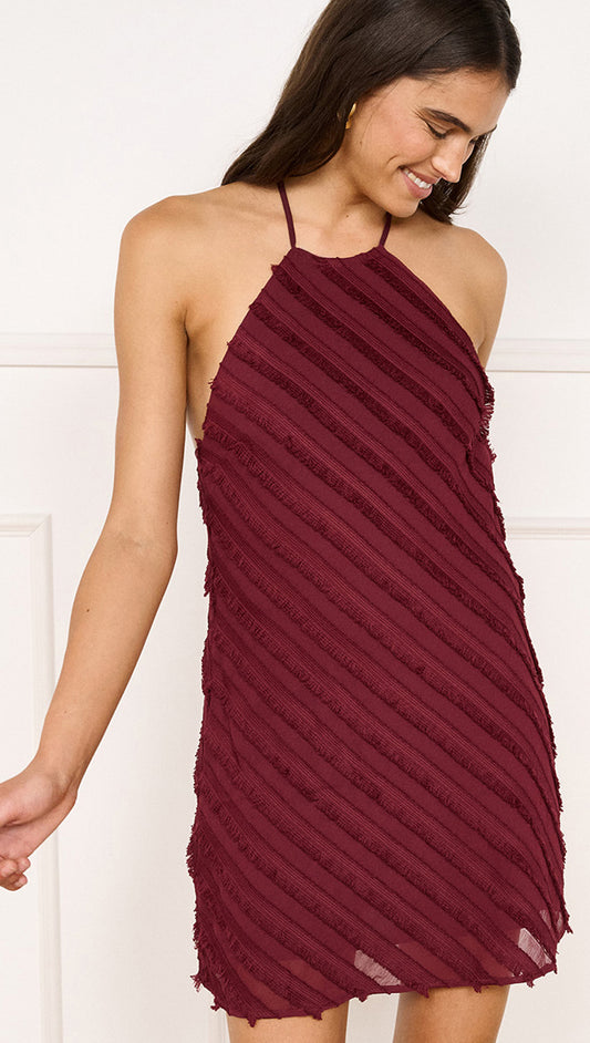 Fringe Detail Halter Mini Dress in Wine worn by a model, showcasing its textural fringe and halter neckline.