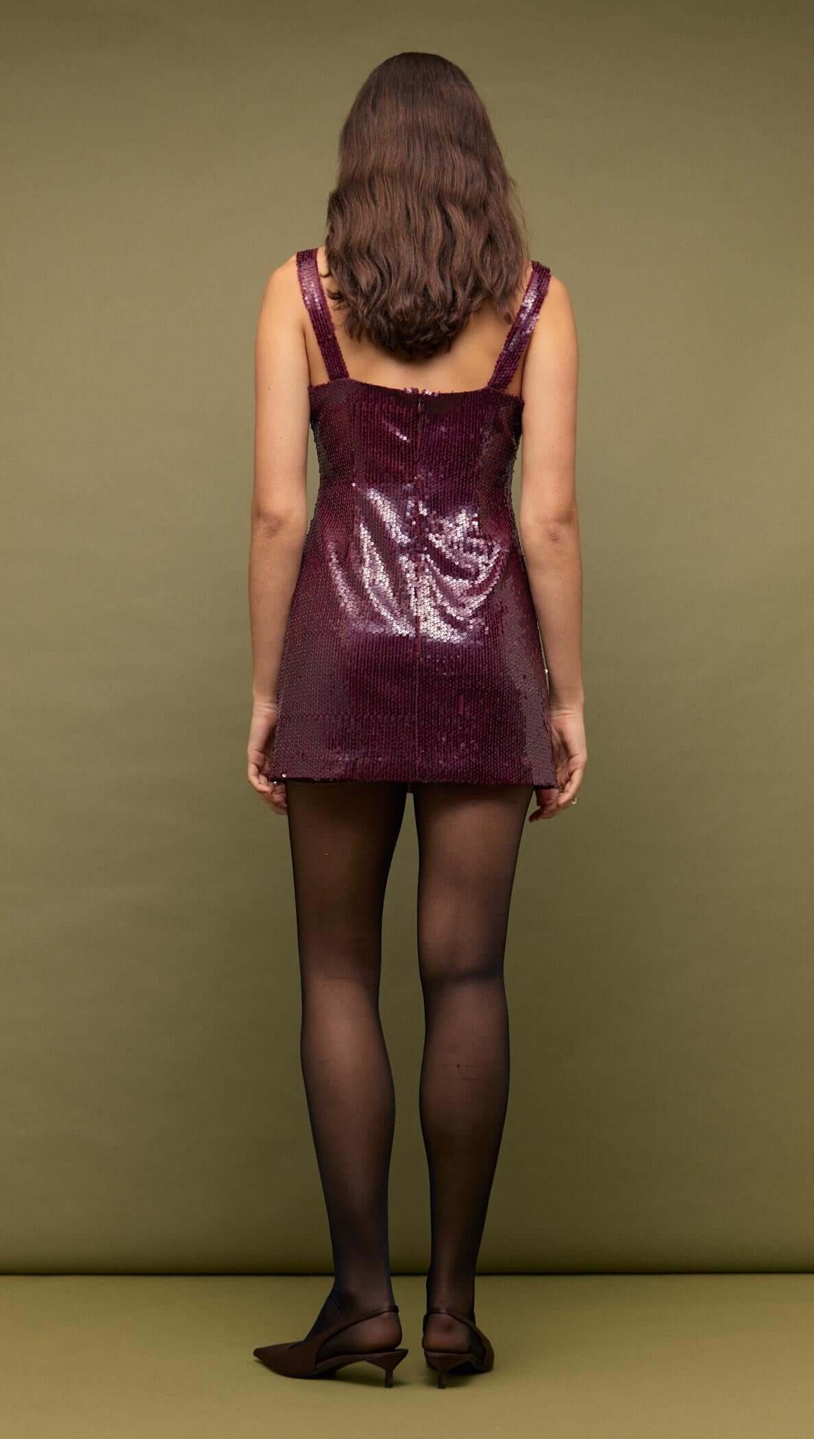 Back view of a model wearing the Purple Sequin Mini Dress with wide straps and burgundy sequins.