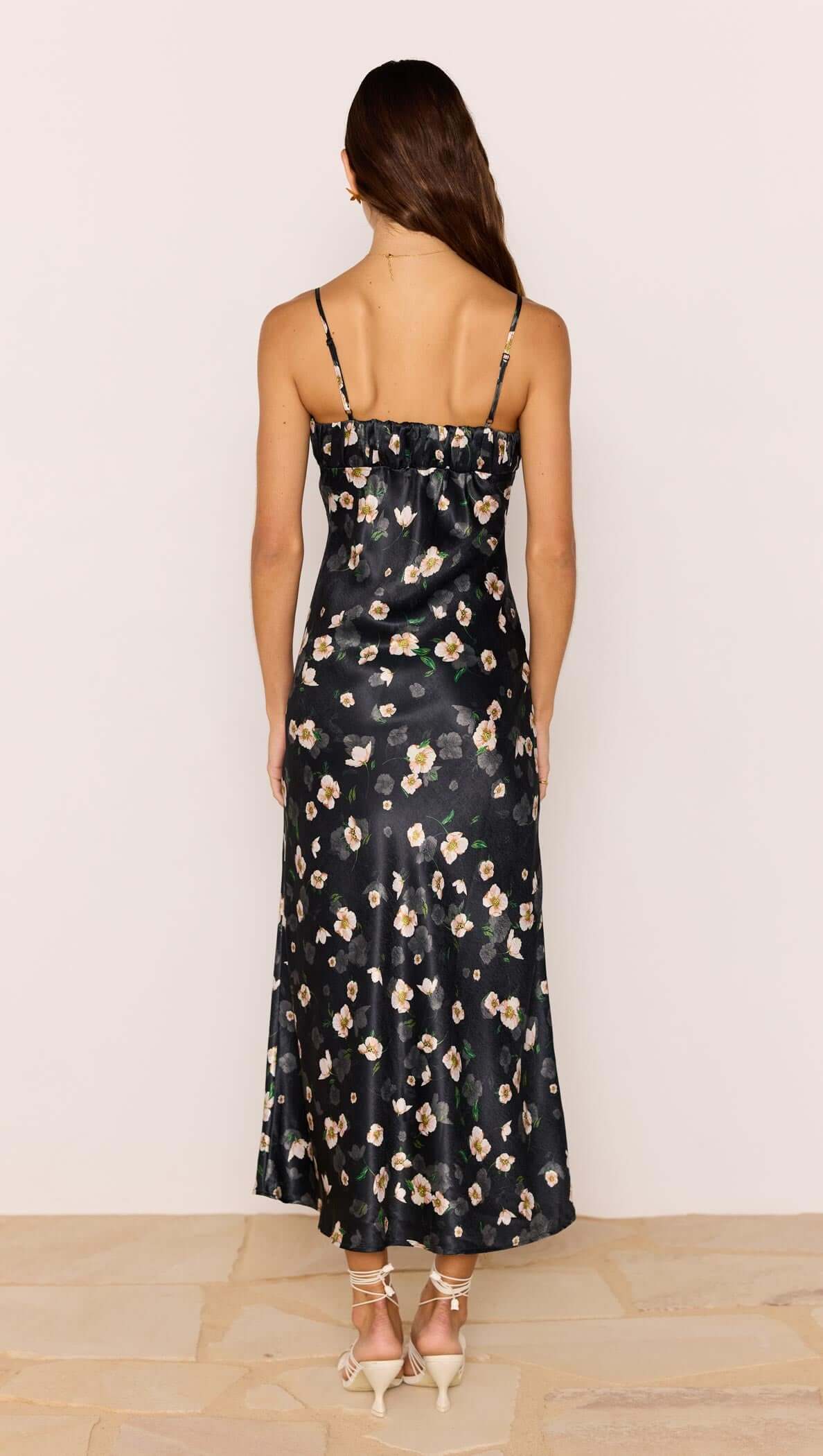 Back view of the Black Floral Bias Midi Dress featuring adjustable straps and a silky floral satin finish.