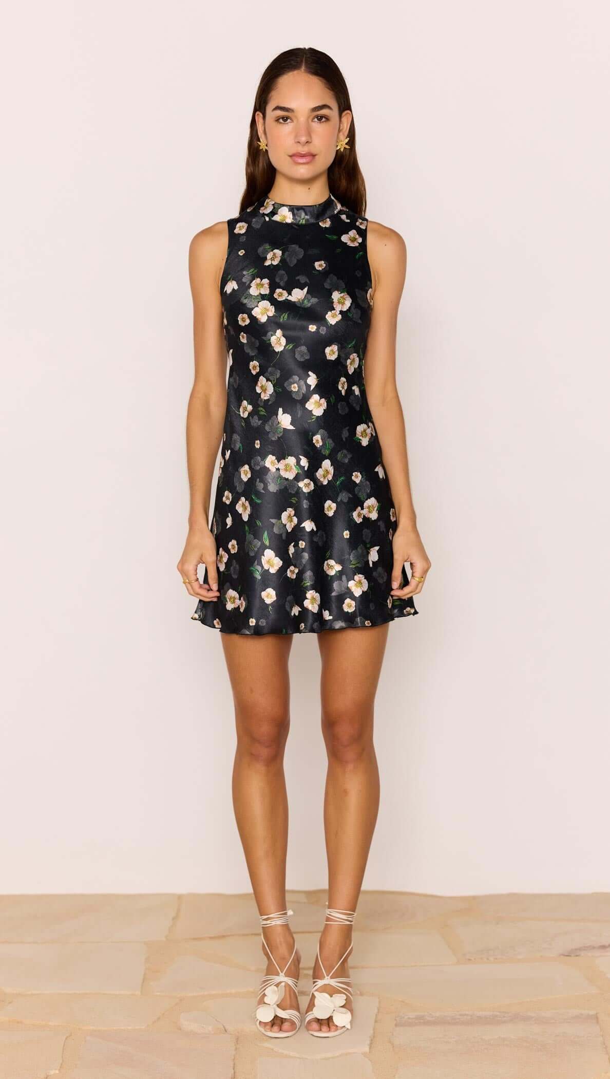 Model wearing a Black Floral Bias Mini Dress featuring a high neckline and open back design.
