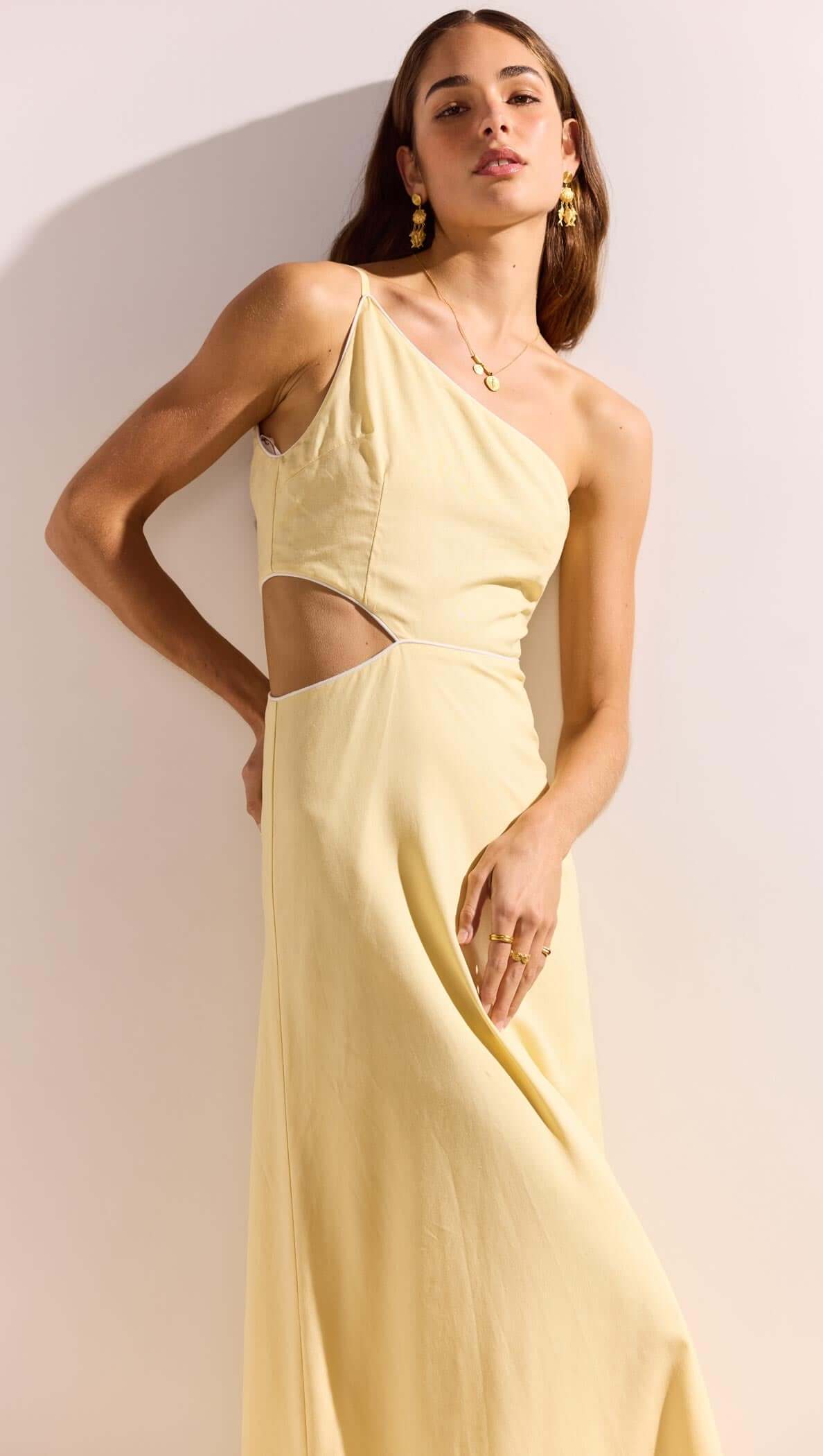 Butter Yellow Asymmetric Cut Out Maxi Dress showcased by a model, highlighting the chic design and flowing fabric.