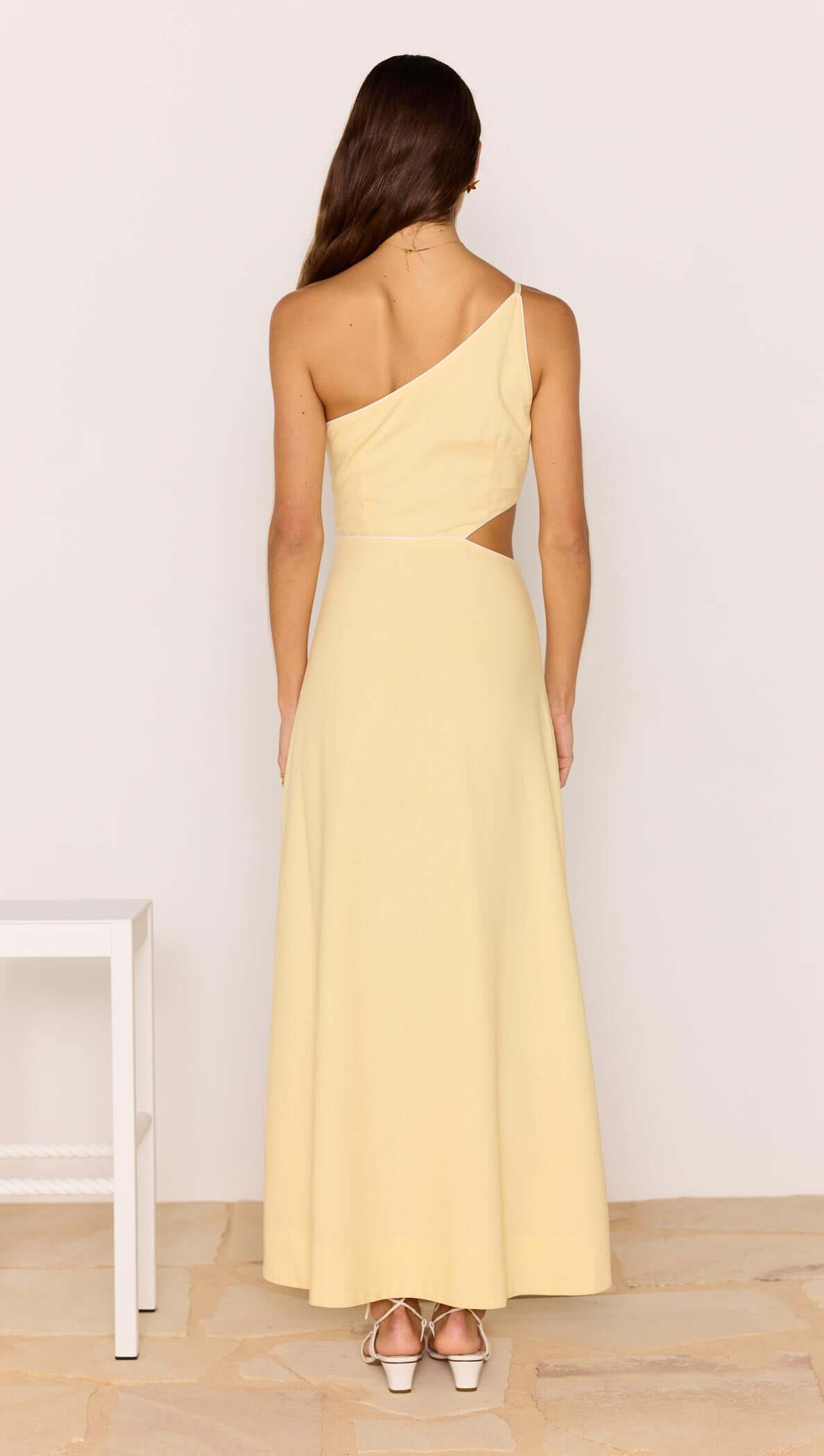 Back view of the Butter Yellow Asymmetric Cut Out Maxi Dress featuring a one-shoulder design and flowing skirt.