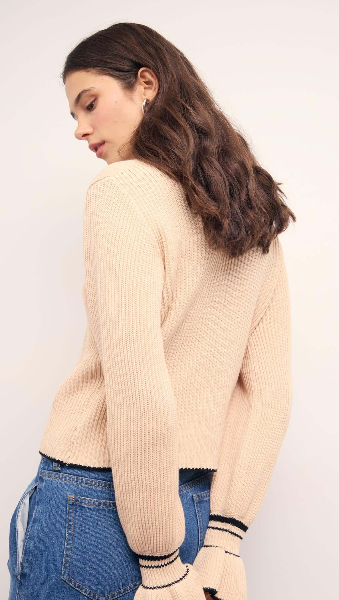 Woman wearing a Cream Knit Top with Contrast Trim, showcasing flared cuffs and a relaxed fit.