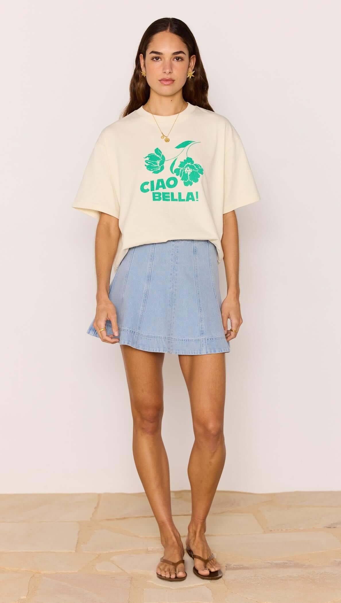 Model wearing a denim flared mini skirt with a graphic tee, showcasing a stylish summer outfit.