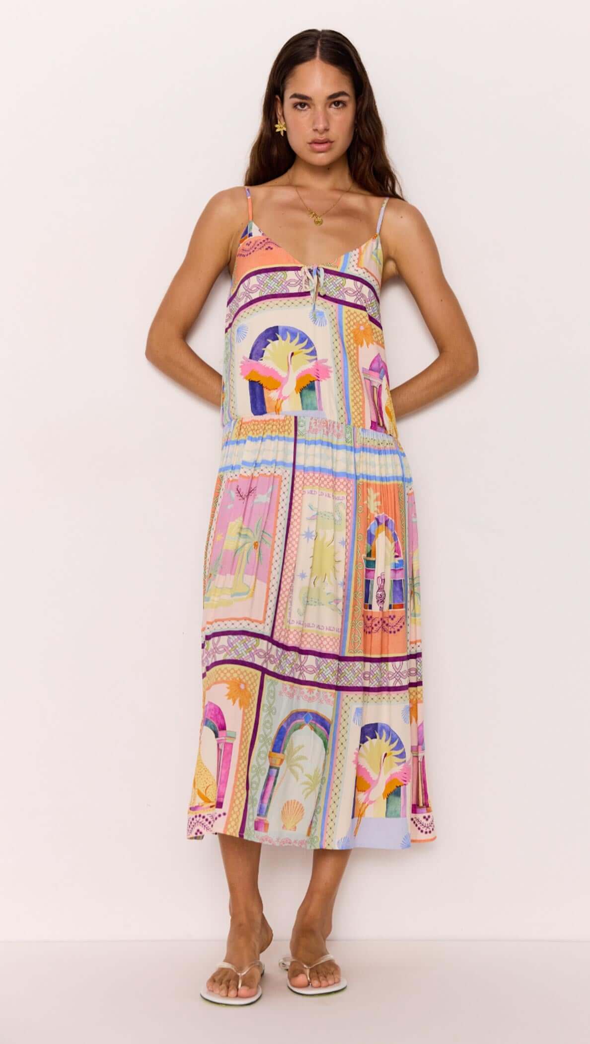 Model wearing a multicolour print dropped-waist strappy midi dress featuring vibrant patterns and a relaxed fit.