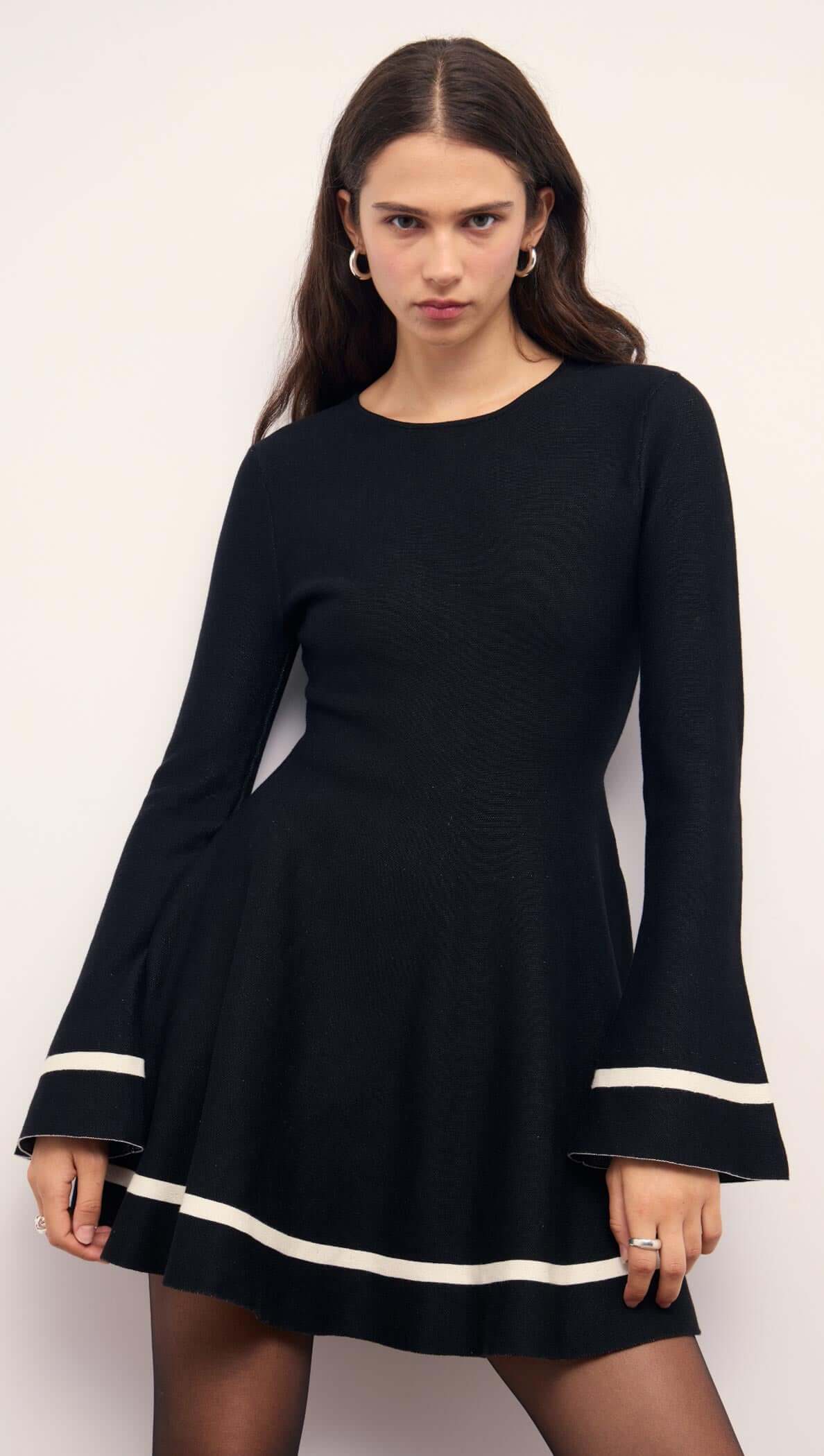 Black Peplum Knit Mini Dress With Contract Trim featuring flared sleeves and chic contrast trim.