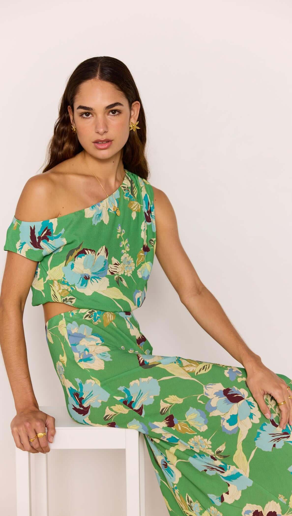Model showcasing the Green Floral Crop Top with one-shoulder design in a vibrant floral print, perfect for summer.