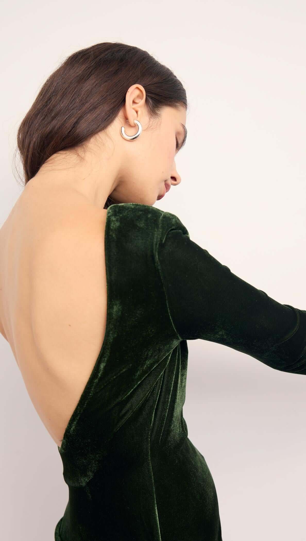 Green Velvet Open Back Mini Dress showcasing its daring open back design and luxurious velvet fabric.