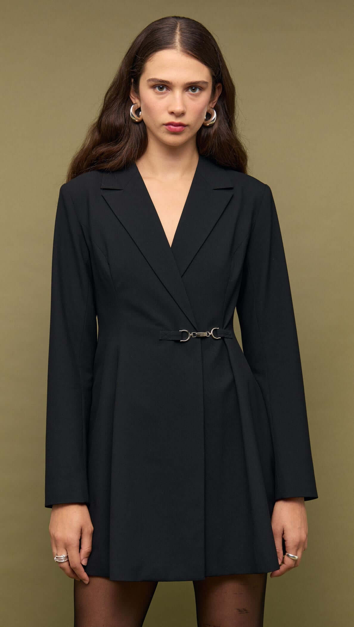 Black Blazer Mini Dress With Buckle Detail worn by a model against a neutral background, showcasing its tailored design.
