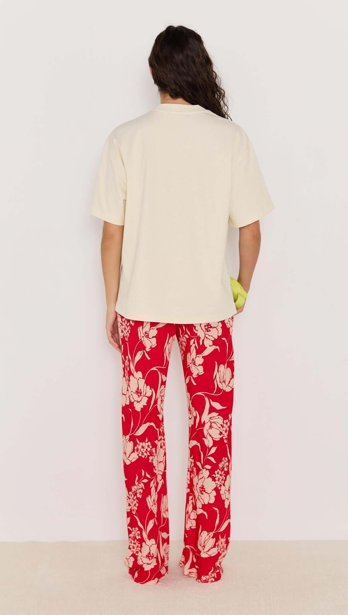 Model wearing cream shirt and red floral Poppy Pants, showcasing the wide leg silhouette and high-rise fit from the back.