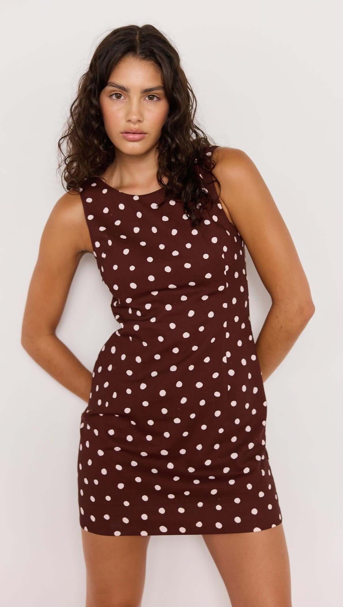 Model wearing the Cedar Mini Dress in chocolate brown spot print with a flattering fit-and-flare silhouette.