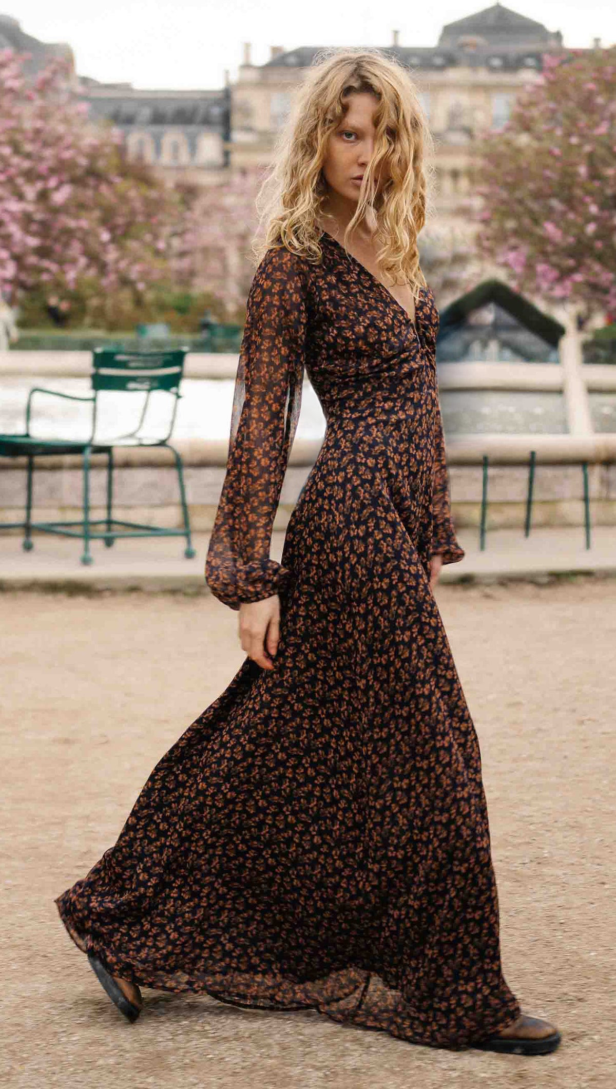 Brown Floral Drape Sleeve Maxi Dress modeled outdoors with a flowing silhouette and drape sleeves.