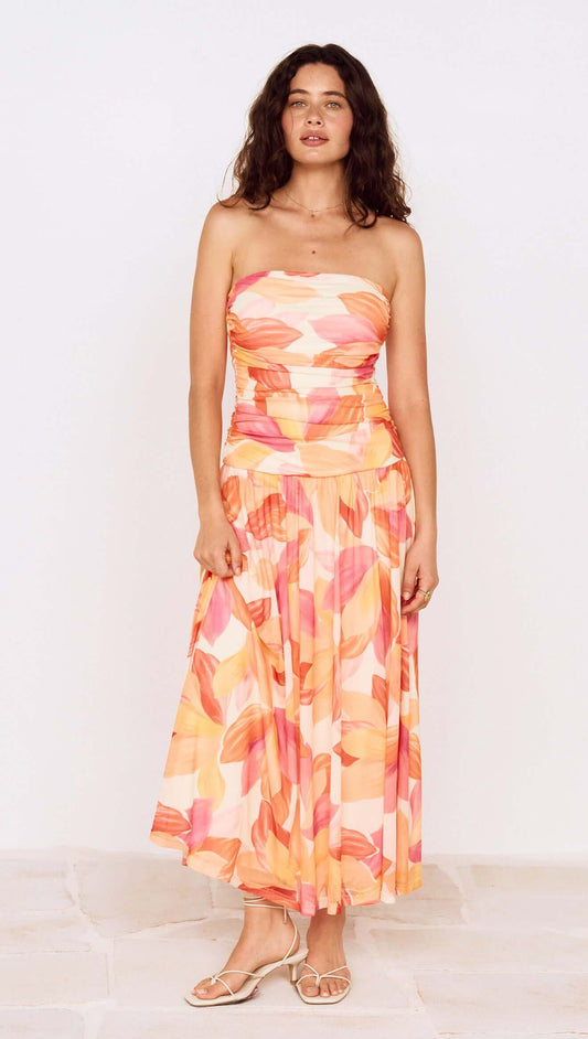 Model wearing a Sunset Leaf Print Sleeveless Midi Dress with a colorful tropical print, perfect for summer occasions.