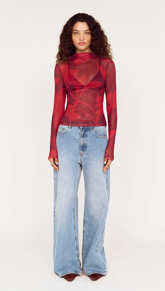Model wearing an Oversized Floral High Neck Mesh Top paired with wide-leg jeans.