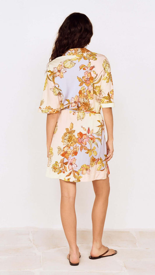 Back view of a woman in a Pastel Floral Mini Shirt Dress showcasing floral patterns and relaxed fit.