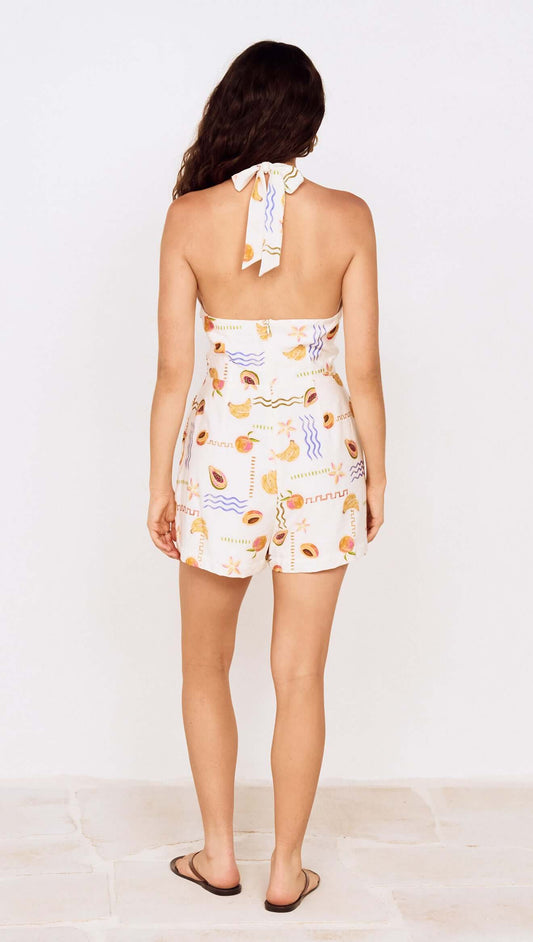 Back view of a woman wearing a Fruit Print Halter Neck Romper with a vibrant fruit-inspired print.