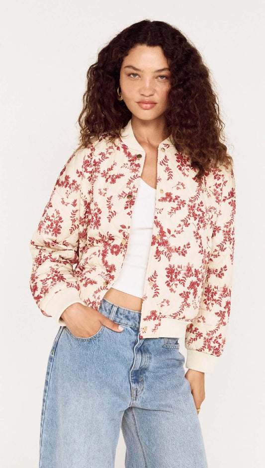 Model wearing the Autumn Floral Quilted Puffer Jacket with a floral pattern and casual jeans, showcasing a stylish fall look.