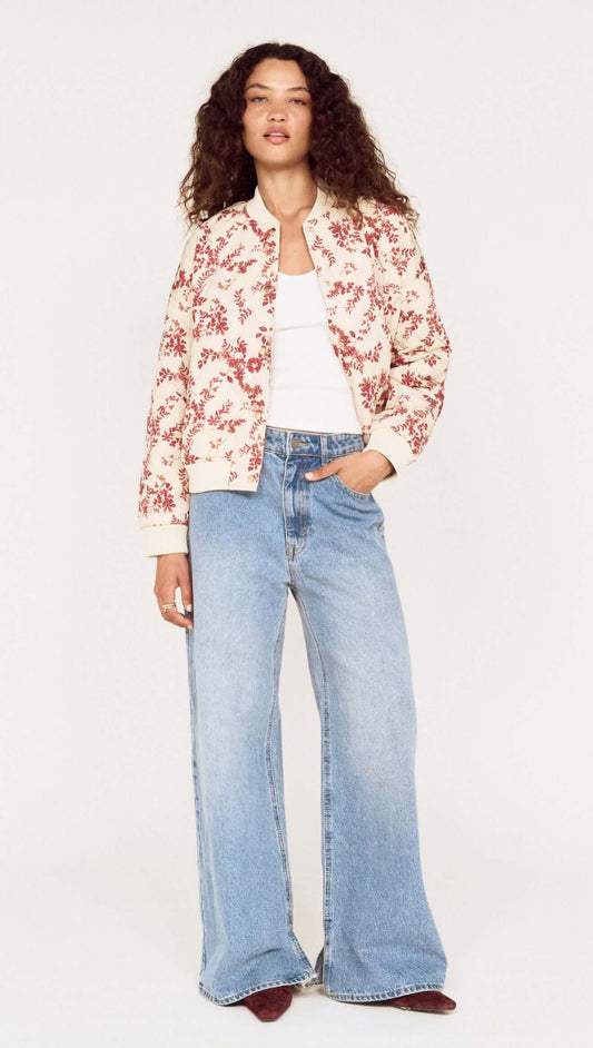 A woman wearing an Autumn Floral Quilted Puffer Jacket with wide-leg jeans, showcasing a stylish autumn look.