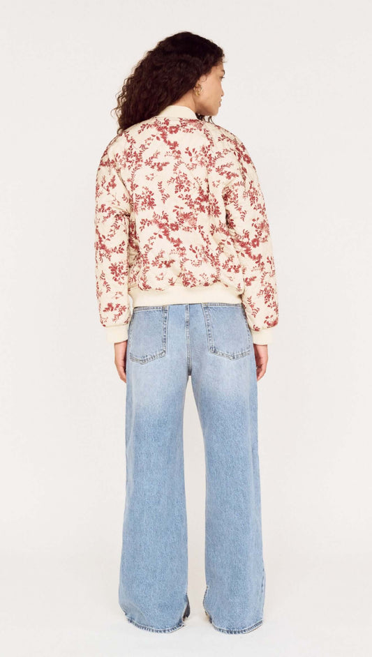 Back view of a model wearing the Autumn Floral Quilted Puffer Jacket paired with wide-leg jeans.