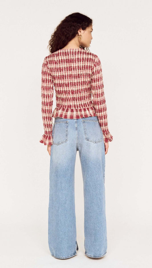 Back view of model wearing the Frill Detail Check Print Shirred Top with wide-leg jeans, showcasing the stylish check print design.