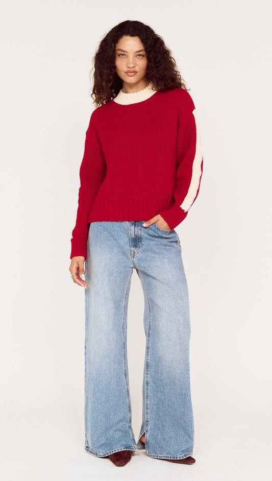 Model wearing the Relaxed Red Contrast Stripe Jumper with wide-leg jeans, showcasing a sporty look and comfortable fit.