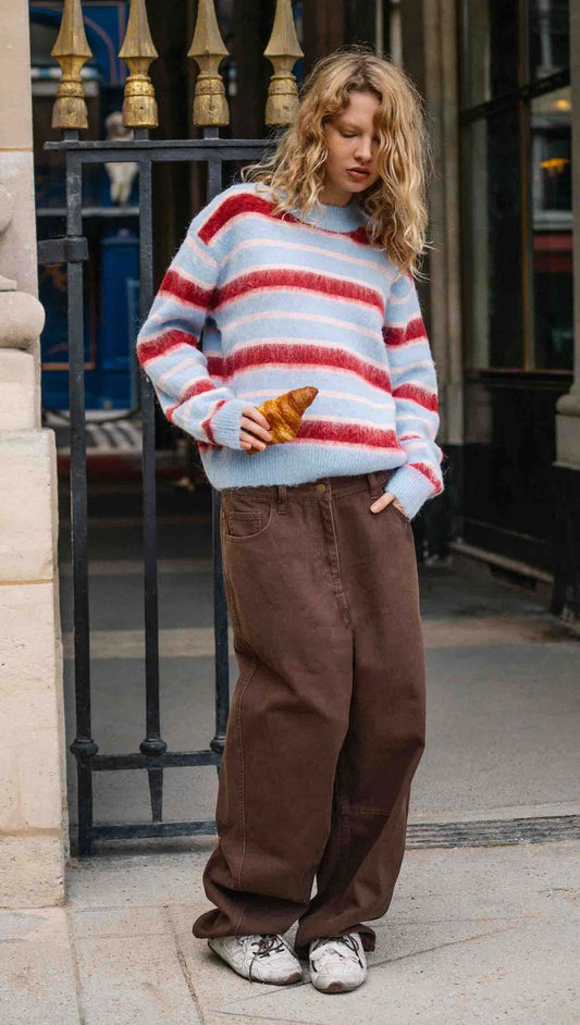 Peppermint Stripe Fluffy Jumper worn by a model outside, featuring bold red and blush stripes on a soft blue background.