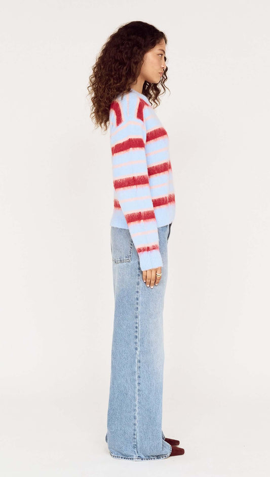Model wearing the Peppermint Stripe Fluffy Jumper with red and blush stripes on a soft blue background.