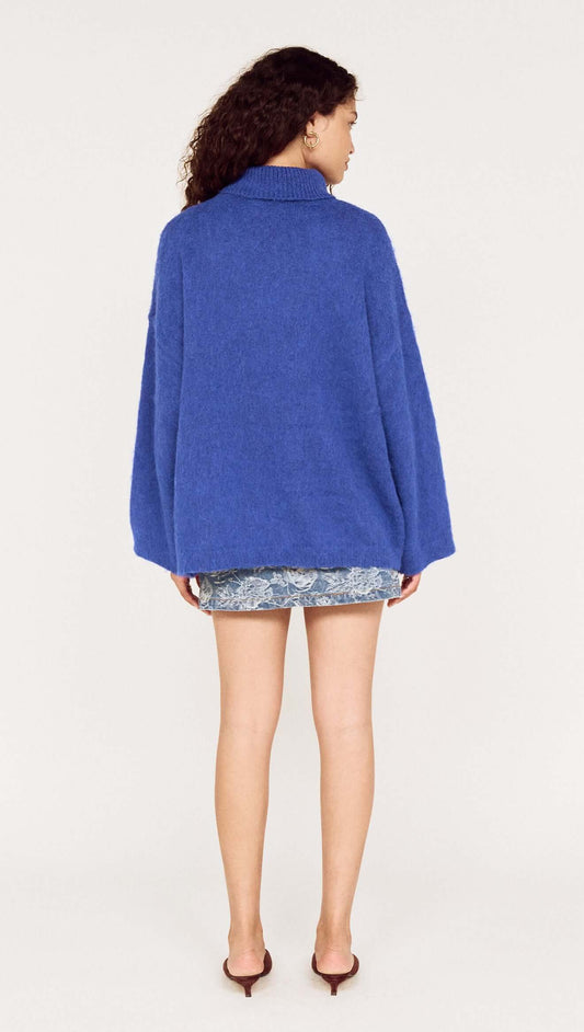 Back view of a model wearing a Blue Oversized Roll Neck Jumper, showcasing its relaxed fit and cozy design.