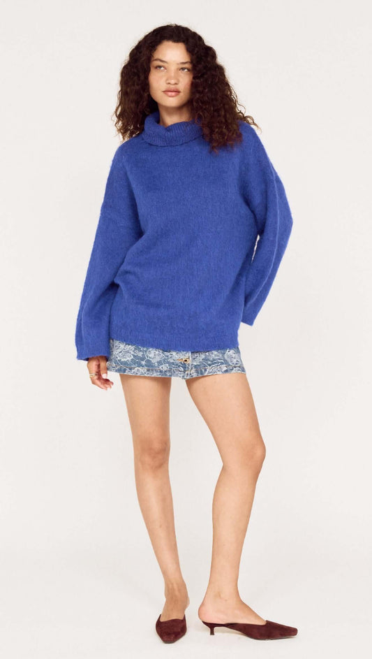 Model wearing a Blue Oversized Roll Neck Jumper with shorts, showcasing a cozy and stylish look.