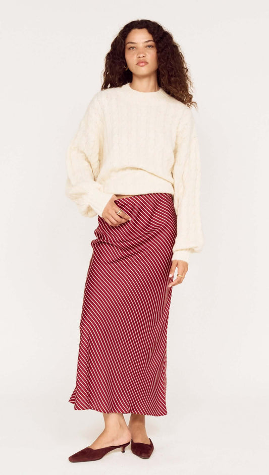 Model wearing a Cream Relaxed Fit Cable Knit Jumper with a striped skirt for a stylish winter outfit.