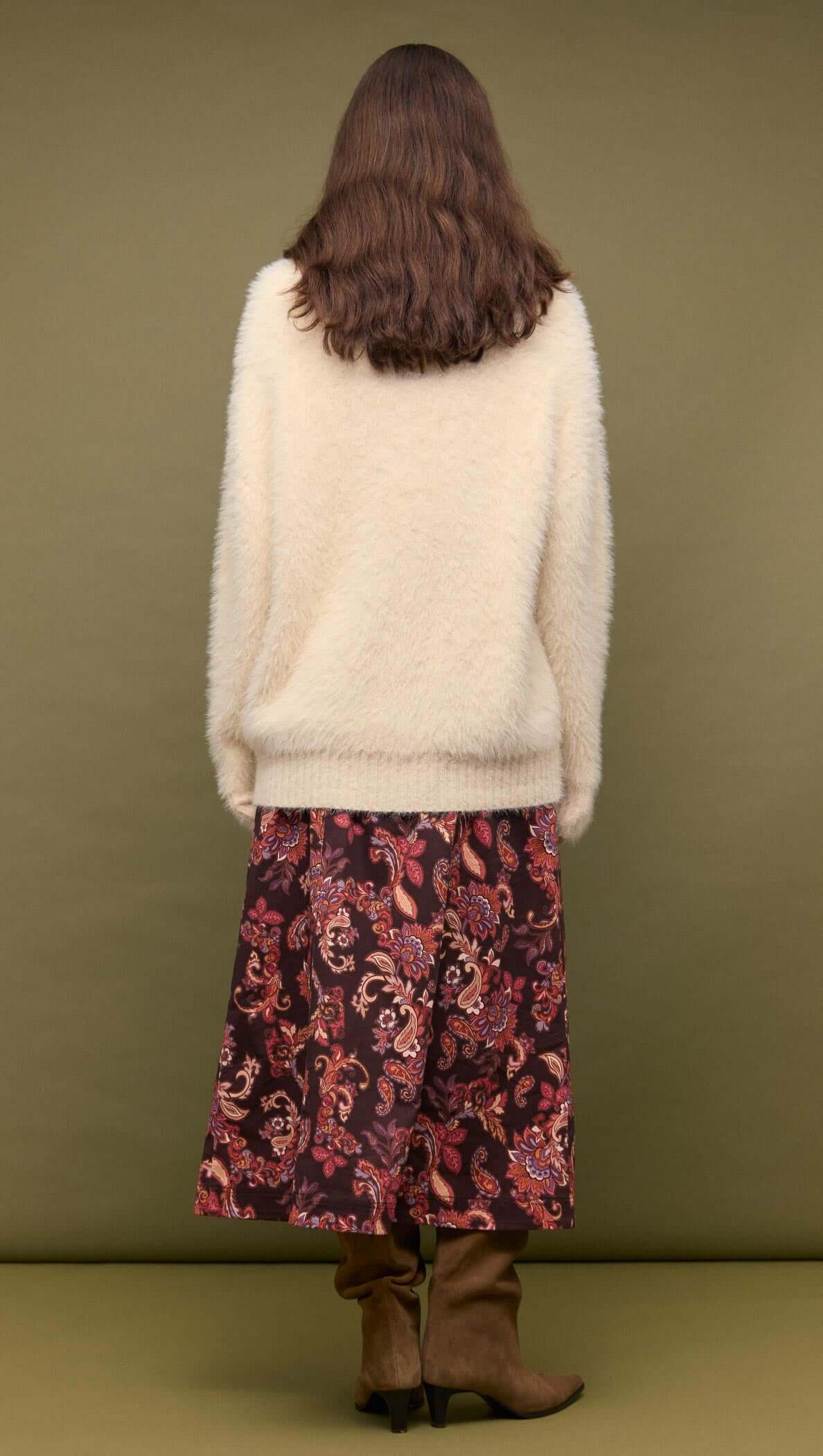 Back view of a model wearing a Cream oversized Fluffy Knit Sweater with a floral skirt.