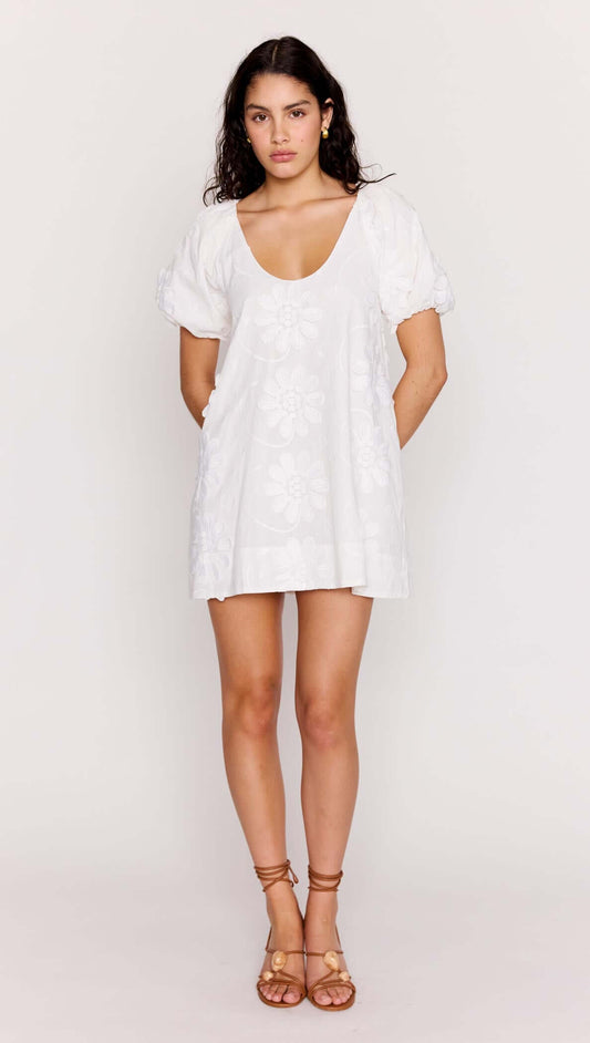 White Cotton Floral Applique Smock Mini Dress on model with puff sleeves and scoop neckline in soft cotton.