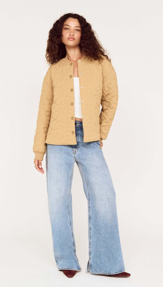 Beige Floral Quilted Puffer Jacket worn by a model, featuring a quilted design and relaxed fit, styled with wide-leg jeans.