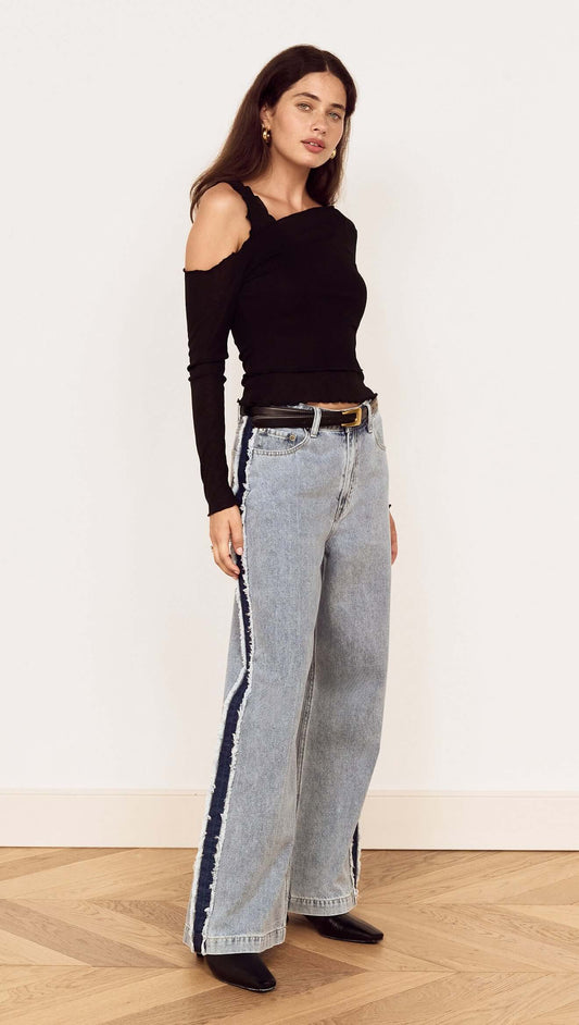 Model showcasing the Black Asymmetric Layered Mesh Top paired with trendy wide-leg jeans.