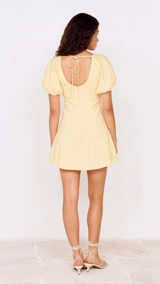 Butter Yellow Puff Sleeve Mini Dress showcasing the back view with a tie detail and a flared skirt.