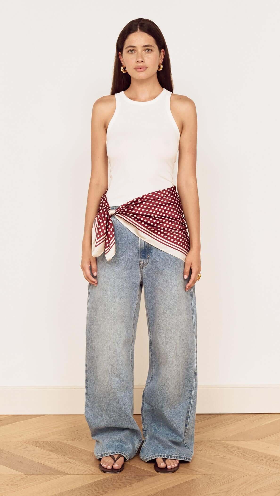 Model wearing Chocolate Polka Dot Scarf styled as a waist scarf with casual outfit.