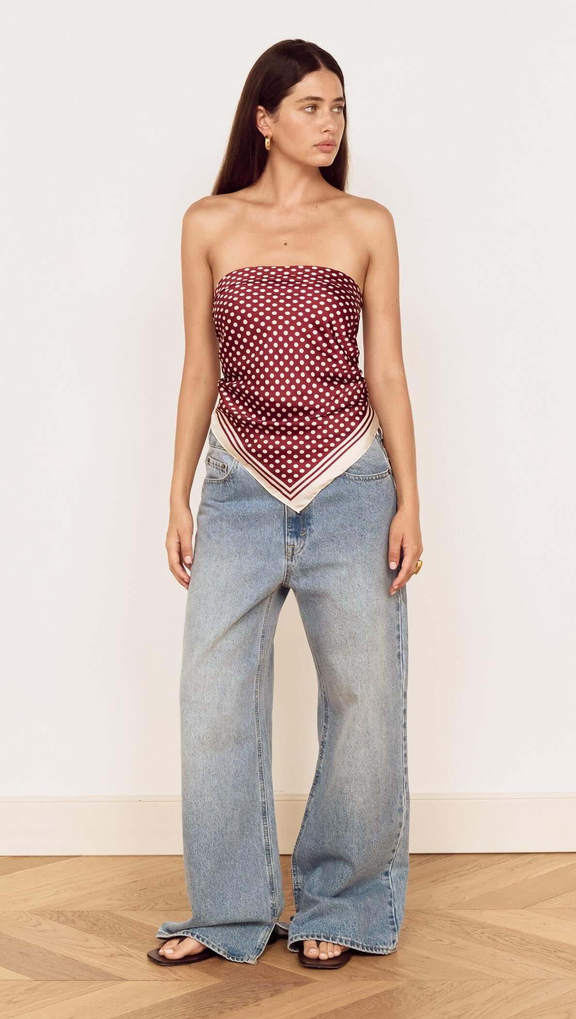 Model wearing a Chocolate Polka Dot Scarf styled as a bandeau top with wide-leg jeans.