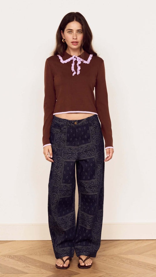 Model wearing the Chocolate Ruffle Collar Polo Knit Top with relaxed denim for a stylish look.
