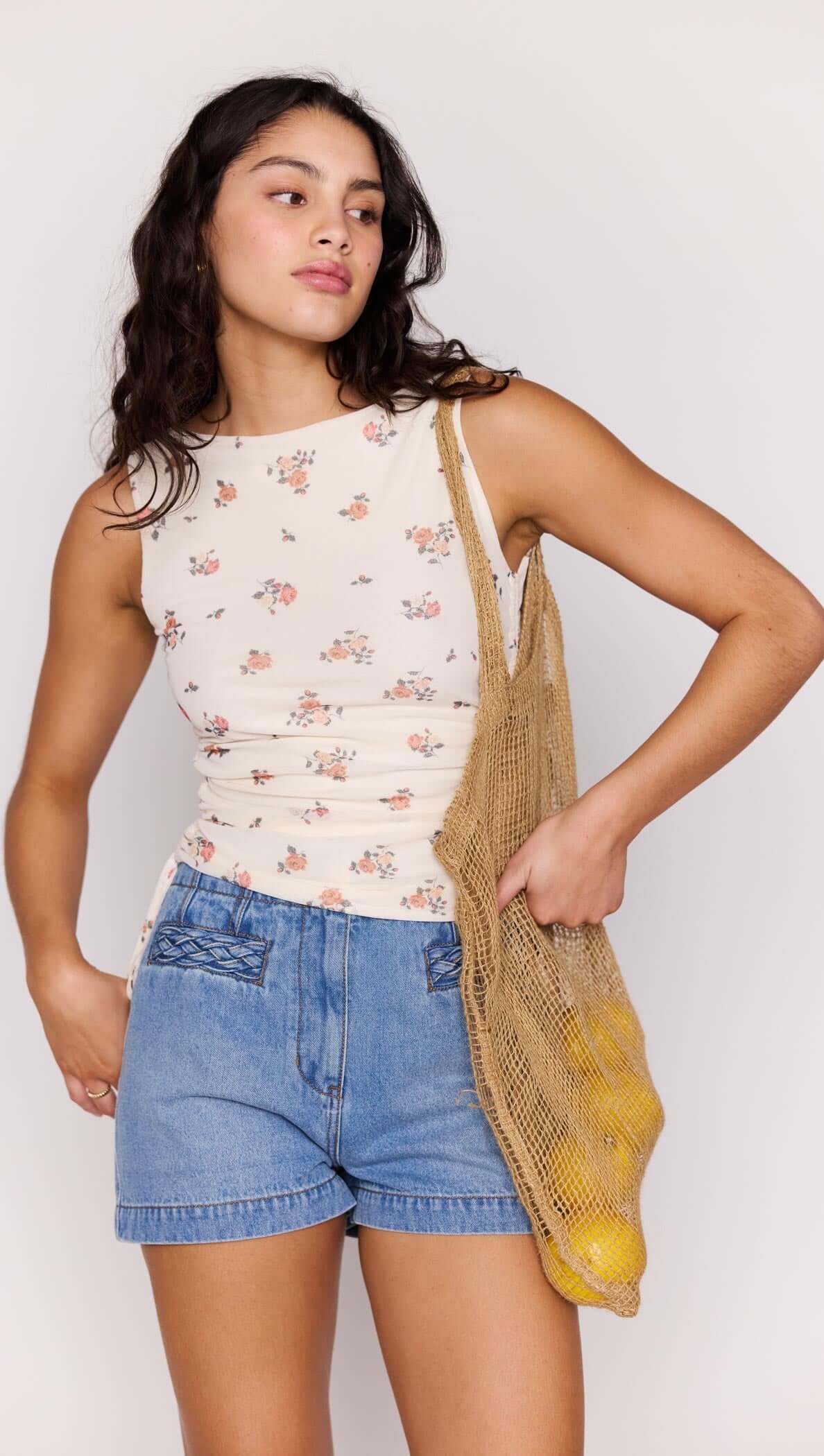 Cream Floral Boat Neck Mesh Top worn by a woman, paired with denim shorts and a woven bag.