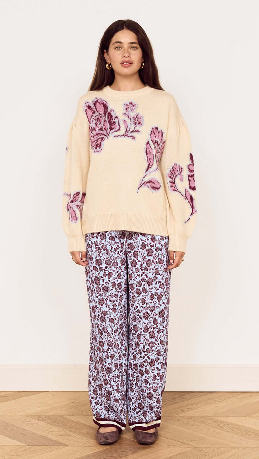 A model wearing the Cream Floral Intarsia Knit Sweater with floral design, paired with printed pants.